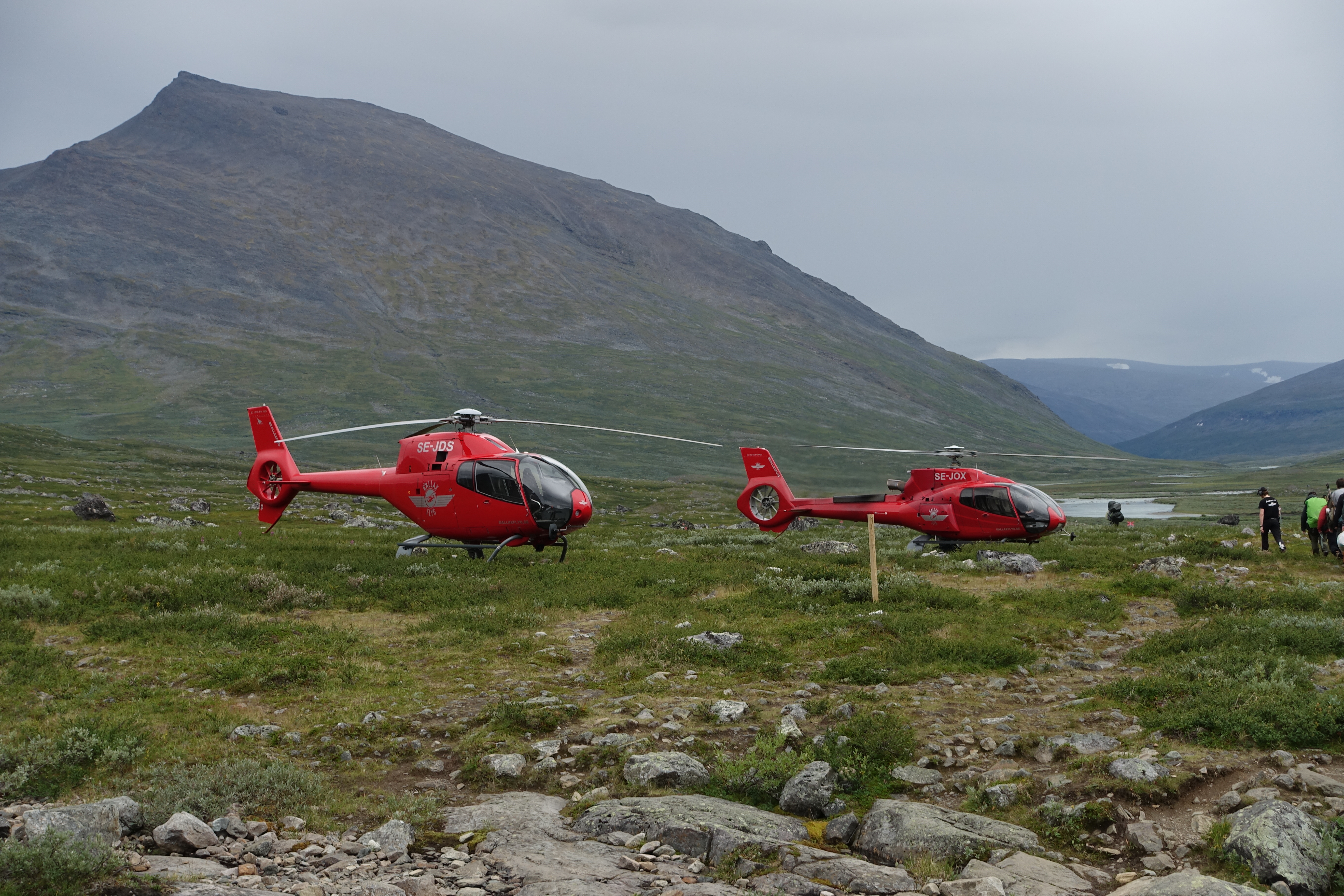 Helikoptrar väntar på att flyga ut turister vid Singistugorna